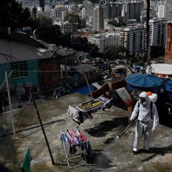 Un voluntario desinfecta un área de la azotea dentro de Santa Marta Favela, en Río de Janeiro, Brasil, durante la pandemia de COVID-19. | Foto:CARL DE SOUZA / AFP