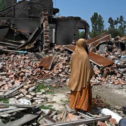 Una mujer inspecciona los escombros de las casas de sus familiares que fueron arrojados por morteros disparados por soldados indios durante un tiroteo con rebeldes, en Sopore, al norte de Srinagar. | Foto:TAUSEEF MUSTAFA / AFP