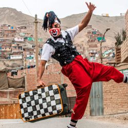 Un payaso con máscara facial poa para una foto antes de actuar en el distrito de Puente Piedra, en las afueras del norte de Lima, durante la pandemia de COVID-19.  | Foto:Ernesto Benavides / AFP