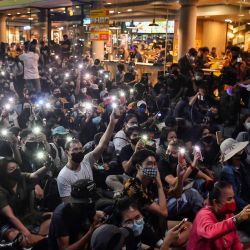 Los manifestantes usan teléfonos móviles como linternas mientras cantan para protestar canciones durante una manifestación antigubernamental con temática de Harry Potter en el Monumento a la Democracia en Bangkok. | Foto:LILLIAN SUWANRUMPHA / AFP