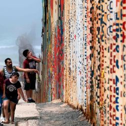 Una familia camina cerca de la valla fronteriza México-Estados Unidos en Playas de Tijuana, estado de Baja California, México, en medio de la pandemia de coronavirus COVID-19. | Foto:Guillermo Arias / AFP