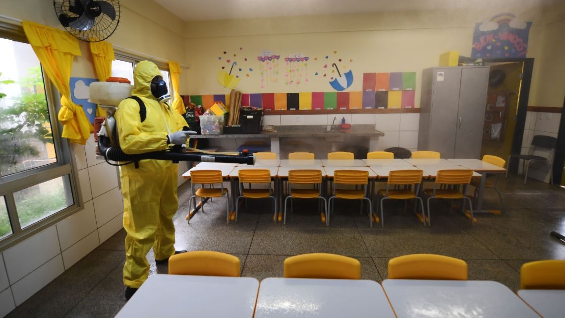 A Federal District's employee disinfects a public school as a measure against the spread of the new coronavirus in Brasilia, on August 5, 2020. 