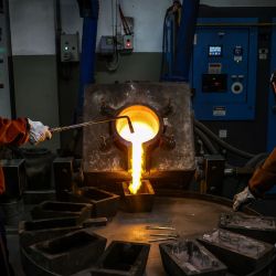 Los trabajadores vierten oro fundido en moldes de un horno en la Refinería ABC en Sydney. | Foto:DAVID GREY / AFP