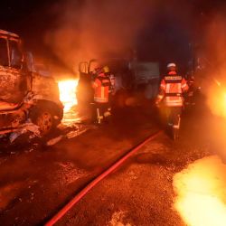 Bomberos desconocidos incendiaron camiones cerca de Temuco, región de la Araucanía, Chile. - 20 vehículos de una empresa de arados fueron quemados como parte de una serie de agresiones presuntamente de grupos indígenas radicales mapuche. | Foto:MARIO QUILODRÁN / AFP