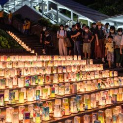 La gente visita el Parque de la Paz de Nagasaki mientras se ven linternas con mensajes para conmemorar el 75 aniversario del bombardeo atómico, en Nagasaki. | Foto:Philip Fong / AFP