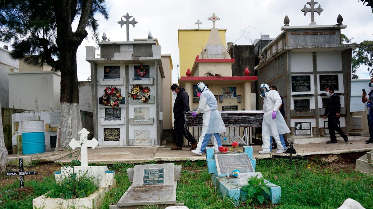 Sepultureros vestidos con trajes de bioseguridad y familiares trasladan un ataúd con los restos de una víctima del COVID-19 en el cementerio municipal de Mixco, en Mixco, a 20 km al oeste de la ciudad de Guatemala. | Foto:Johan Ordonez / AFP
