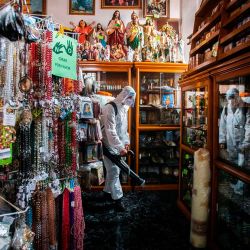 Un trabajador de limpieza que usa equipo de protección personal desinfecta en la tienda de la catedral de Morelia, en el estado de Michoacán, en medio de la pandemia del nuevo coronavirus. | Foto:ENRIQUE CASTRO / AFP