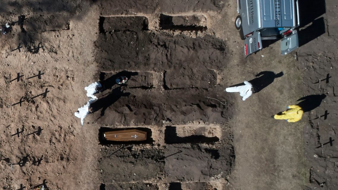 Aerial view of workers burying a coffin in an area cleared to accomodate new graves to cope with demand during the coronavirus pandemic, in the Chacarita cemetery in Buenos Aires, on August 11, 2020.