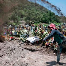 Un sepulturero cava una tumba durante un funeral en el cementerio de San Miguel Xico, en medio de la pandemia del coronavirus COVID-19. | Foto:PEDRO PARDO / AFP