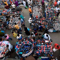 La gente se abre camino y compra artículos en los puestos de un mercado en Dhaka. | Foto:Munir Uz zaman / AFP