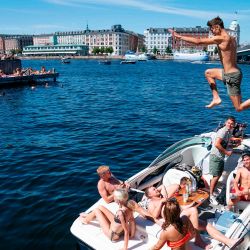 Un joven salta al agua desde el muelle del puerto de Copenhague en un soleado. - Una ola de calor golpeó Dinamarca, ya que se supone que las altas temperaturas durarán todo el fin de semana. | Foto:Claus Bech / Ritzau Scanpix / AFP