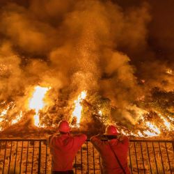 Los bomberos miran el humo y las llamas que se elevan desde el incendio del rancho en las montañas de San Gabriel sobre Azusa, a 25 millas al este de Los Ángeles, California. | Foto:Apu Gomes / AFP