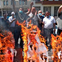 Los manifestantes palestinos colocaron recortes en llamas que mostraban los rostros del primer ministro israelí (Benjamin Netanyahu, el príncipe heredero de Abu Dhabi, el jeque Mohammed bin Zayed al-Nahyan, y el presidente de los Estados Unidos, Donald Trump, durante una manifestación en Naplusa en la ocupada Cisjordania). | Foto:JAAFAR ASHTIYEH / AFP