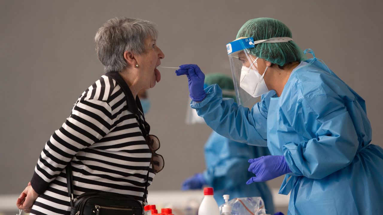 Un trabajador de la salud usa un hisopo para recolectar una muestra de una mujer en un centro de pruebas temporal para el nuevo coronavirus en la ciudad vasca española de Azpeitia luego de un nuevo brote en la ciudad. | Foto:ANDER GILLENEA / AFP