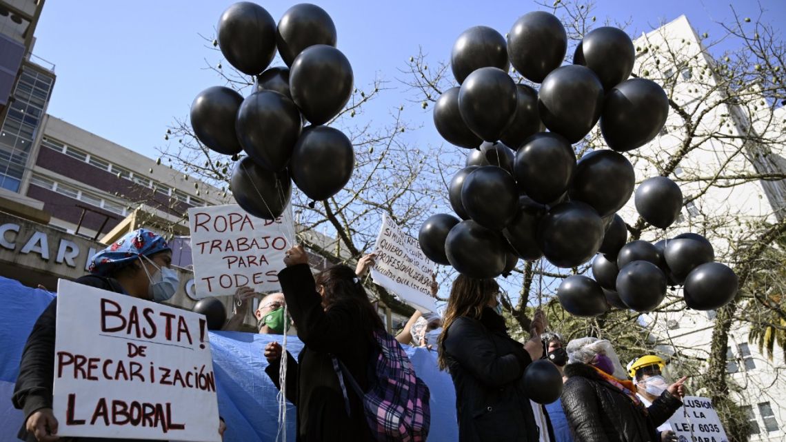 Health workers with flags and black balloons demand better working conditions and pay homage to late nurse Grover Licona, who died from Covid-19, outside the Carlos G. Durand hospital in Buenos Aires, on August 18, 2020.