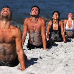 Matthew Levitz y miembros del Jetty Fitness Club entrenan en la playa con lo que ellos llaman un entrenamiento  | Foto:Al Bello / Getty Images / AFP