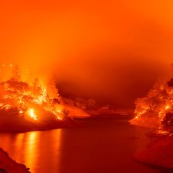 En esta fotografía de larga exposición, las llamas consumen ambos lados de un segmento del lago Berryessa durante el incendio de Hennessey en el área plana española de Napa, California. | Foto:JOSH EDELSON / AFP