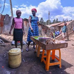 Bella Achieng, trabaja con su madre Lilian Adhiambo en su puesto de comestibles al aire libre cerca de su casa en el barrio pobre de Kibera, en Nairobi, mientras las escuelas permanecen cerradas en todo el país luego de un gobierno directiva como medida para detener la propagación del COVID-19. | Foto:TONY KARUMBA / AFP