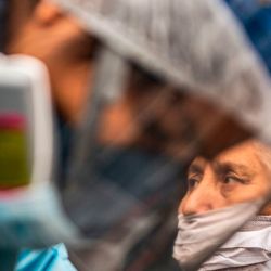 Un trabajador del Ministerio de Salud peruano examina y realiza una prueba para descartar COVID-19 en pacientes mayores de 60 años en sus casas de la colonia Perales, distrito de Santa Anita, al este de Lima. | Foto:Ernesto Benavides / AFP