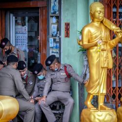 Policías tailandeses se refugian de la lluvia junto a estatuas de Buda durante una manifestación a favor de la democracia frente a la sede de la Autoridad Metropolitana de Bangkok en Bangkok. | Foto:Mladen Antonov / AFP