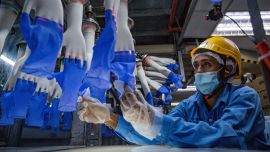 Un trabajador inspecciona guantes desechables en la fábrica Top Glove en Shah Alam en las afueras de Kuala Lumpur. - Top Glove, una empresa con sede en Malasia es uno de los mayores fabricantes de guantes de goma del mundo.