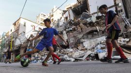 Los niños juegan con una pelota de fútbol entre los escombros y la destrucción a lo largo de una calle en el distrito de Gemmayzeh de la capital del Líbano, Beirut, a raíz de la explosión del monstruo en el puesto cercano que devastó la ciudad.