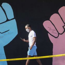 Un hombre pasa junto al arte callejero inspirado en el movimiento Black Lives Matter en Los Ángeles, California. | Foto:Mario Tama / Getty Images / AFP