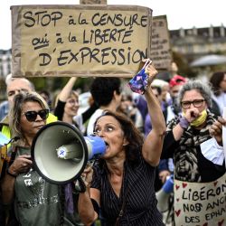 Una mujer que sostiene un cartel que dice  | Foto:Christophe Archambault / AFP