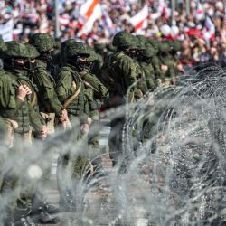 Los militares bielorrusos se paran detrás de una cerca de alambre de púas durante una manifestación de partidarios de la oposición para protestar contra los resultados de las elecciones presidenciales disputadas en Minsk. | Foto:TUT.BY / AFP