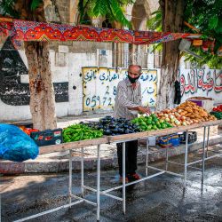 Un vendedor ambulante palestino vestido con una máscara organiza productos en su puesto a lo largo de una calle en la ciudad de Gaza, en medio de un cierre impuesto por la pandemia del coronavirus COVID-19. | Foto:MOHAMMED ABED / AFP