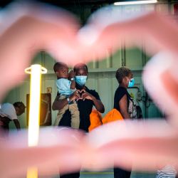 Los migrantes rescatados hacen fila y forman corazones con sus manos antes de abandonar el barco de rescate Sea-Watch 4 antes de abordar un ferry, en el que unos 350 migrantes estarán en cuarentena, frente a la costa de Palermo, Sicilia, Italia. | Foto:Thomas Lohnes / AFP