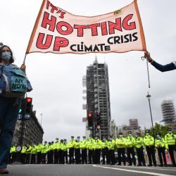 Los activistas sostienen una pancarta que dice  | Foto:JUSTIN TALLIS / AFP