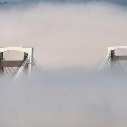 Una densa niebla cubre parcialmente el puente de Rande de 150 metros de altura en la bahía de Vigo, en Vigo. | Foto:MIGUEL RIOPA / AFP