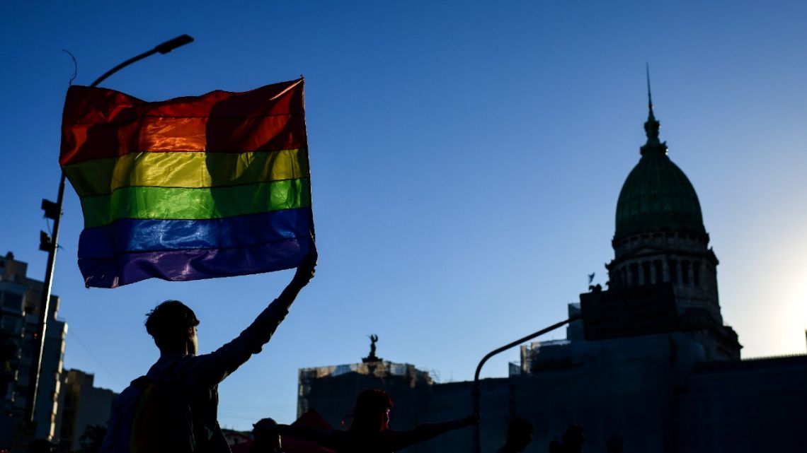 In this file photo taken on November 2, 2019 a reveller holds a rainbow flag during the Gay Pride Parade outside the Congress building in Buenos Aires. Government positions will be reserved for transvestites, transsexuals and transgenders, according to a decree issued on September 4, 2020. 