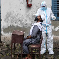 Un personal médico toma una muestra de un hombre para una prueba rápida de antígeno para el coronavirus Covid-19 en un centro de pruebas temporal en una escuela en Nueva Delhi. | Foto:Prakash Singh / AFP