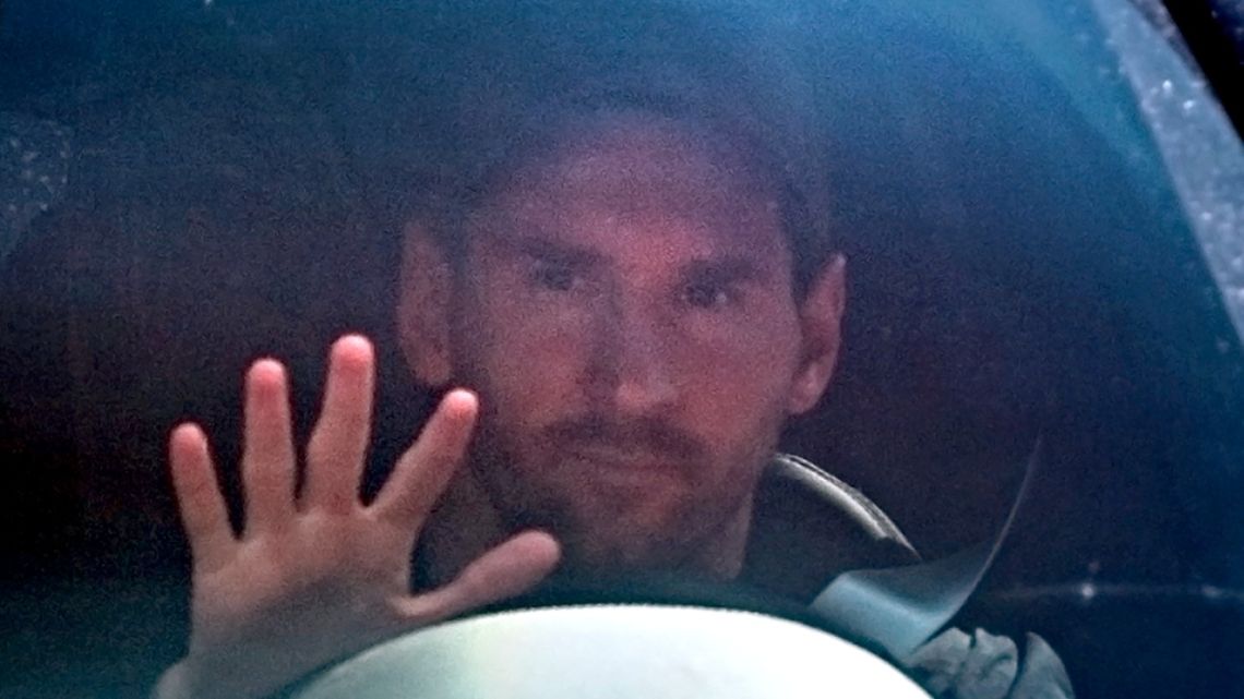 Lionel Messi waves to reporters as he leaves his home and heads to training.