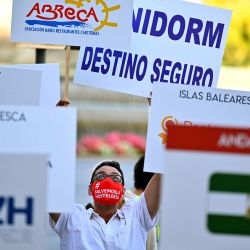 Un manifestante sostiene un cartel que dice  | Foto:GABRIEL BOUYS / AFP
