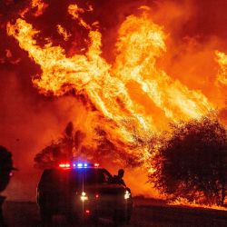 Un oficial de la ley observa cómo las llamas se lanzan al aire mientras el fuego continúa propagándose en el incendio Bear en Oroville, California. | Foto:JOSH EDELSON / AFP