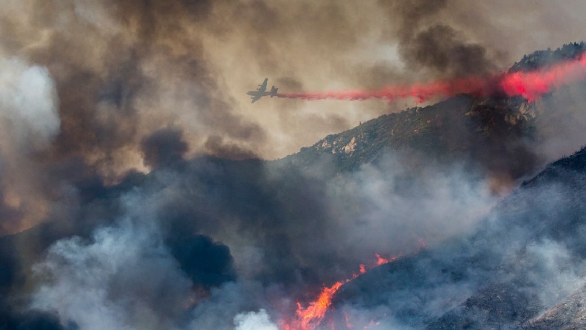In this Saturday, September 5, 2020 file photo, an air tanker drops fire retardant on a hillside wildfire in Yucaipa, California, United States.