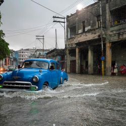 Un automóvil circula por una calle inundada del municipio 10 de Octubre de La Habana. | Foto:YAMIL LAGE / AFP
