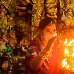 Un devoto hindú realiza un Arti, un ritual religioso hindú, frente a un ídolo de la diosa Durga dentro de su casa en Calcuta. | Foto:Dibyangshu Sarkar / AFP