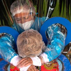 María Hernández, de 38 años, (arriba) abraza a su tía a través de una cortina transparente en un hogar de ancianos Hogar Jardín de Los Abuelitos en San Salvador, en medio de la nueva pandemia de coronavirus. | Foto:Yuri CORTEZ / AFP