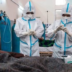 Los trabajadores de la salud tratan a un paciente infectado con COVID-19 en el Centro de Tratamiento y Aislamiento de COVID-19 de Mekele, en Mekele, Etiopía. | Foto:EDUARDO SOTERAS / AFP