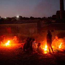 Refugiados y migrantes del campo destruido de Moria cocinan en llamas durante la tarde en la isla de Lesbos. | Foto:ANGELOS TZORTZINIS / AFP