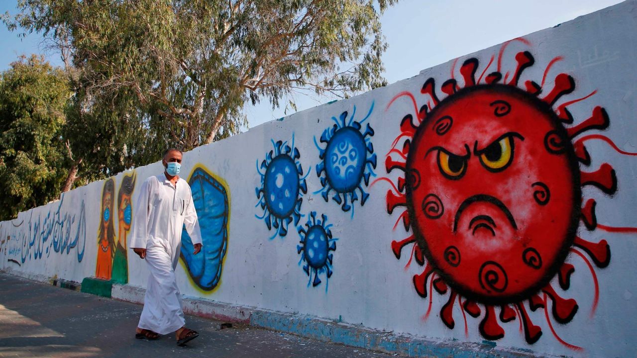 Un hombre palestino pasa junto a un mural de concienciación sobre el coronavirus en Deir Al-Balah en la Franja de Gaza. | Foto:Mohammed Abed / AFP