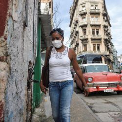 Una mujer con mascarilla contra la propagación del nuevo coronavirus, COVID-19, camina en La Habana. | Foto:Yamil Lage / AFP