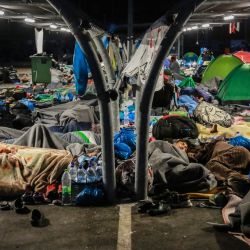 Los migrantes encuentran refugio en el estacionamiento de un supermercad en Lesbos antes de que la policía comenzara una operación para realojar a miles de migrantes sin hogar en un nuevo sitio después de que su campamento fuera destruido por un incendio la semana pasada. | Foto:AFP