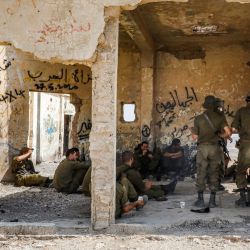 Los soldados israelíes se reúnen dentro de un antiguo edificio construido por Jordania durante un entrenamiento cerca de un campamento militar israelí en la aldea de Yatta en el sur de la Cisjordania ocupada. | Foto:HAZEM BADER / AFP