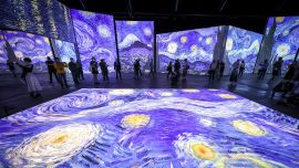 Miembros de los medios de comunicación con máscaras faciales miran una exposición titulada 'Van Gogh Alive' durante una vista previa de los medios en el Royal Hall of Industries en Sydney.