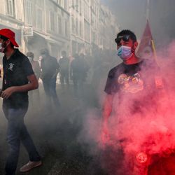 Un hombre quema una bengala mientras participa en una manifestación en Marsella como parte de un día de protestas a nivel nacional convocado por varios sindicatos de trabajadores por salarios y empleos. | Foto:Christophe Simon / AFP